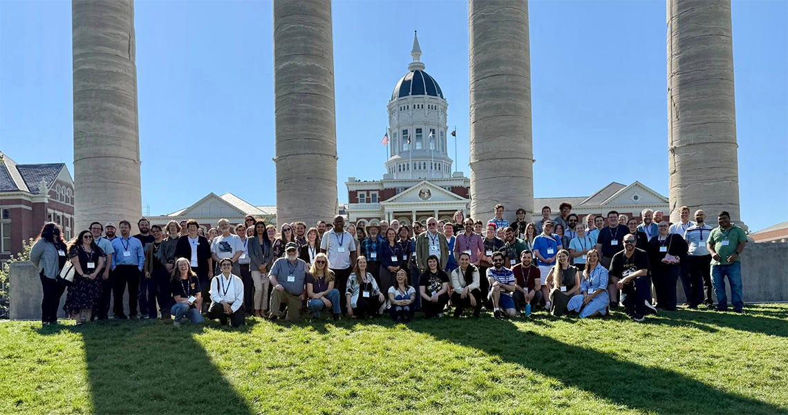 Paleo Conference group in front of columns